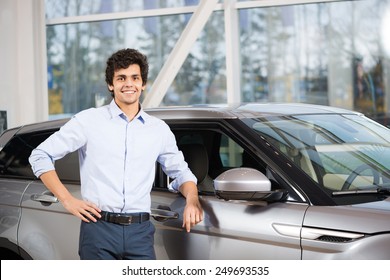 Young Handsome Man At Show Room Standing Near Car