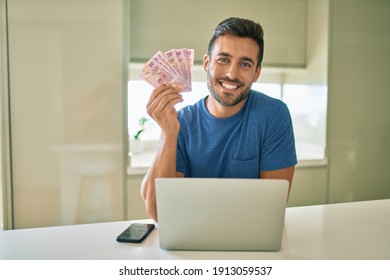 Young handsome man smiling happy holding mexican pesos banknotes at home