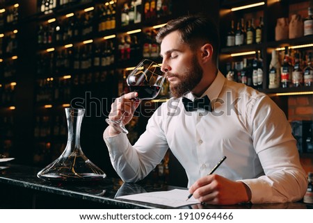 Young handsome man sommelier tasting red wine in cellar Foto stock © 
