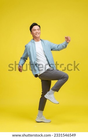 Young handsome man standing over isolated yellow background very happy and excited doing winner gesture with arms raised Foto d'archivio © 