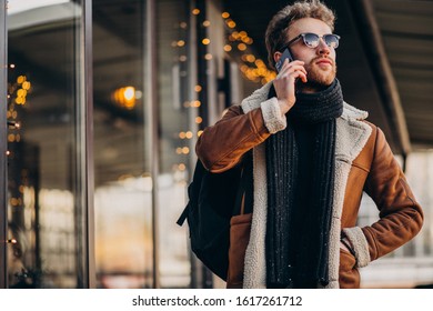 Young handsome man talking on phone by the airport - Shutterstock ID 1617261712
