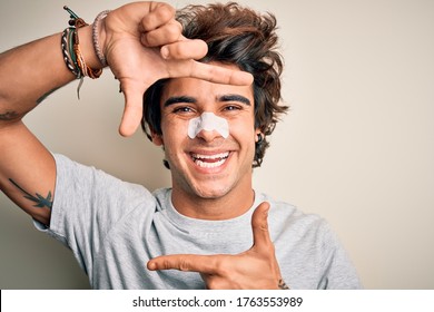 Young handsome man using nose strip standing over isolated white background smiling making frame with hands and fingers with happy face. Creativity and photography concept.