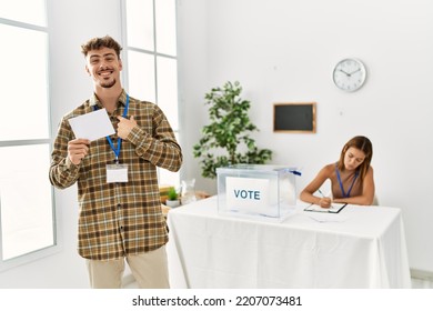 Young Handsome Man Voting Putting Envelop In Ballot Box Pointing Finger To One Self Smiling Happy And Proud 