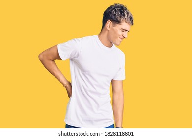 Young Handsome Man Wearing Casual White Tshirt Suffering Of Backache, Touching Back With Hand, Muscular Pain 