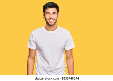 Young Handsome Man Wearing Casual White Tshirt With A Happy And Cool Smile On Face. Lucky Person. 