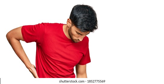 Young Handsome Man Wearing Casual Red Tshirt Suffering Of Backache, Touching Back With Hand, Muscular Pain 