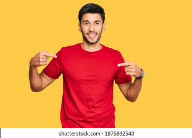 Young Handsome Man Wearing Casual Red Tshirt Looking Confident With Smile On Face, Pointing Oneself With Fingers Proud And Happy. 