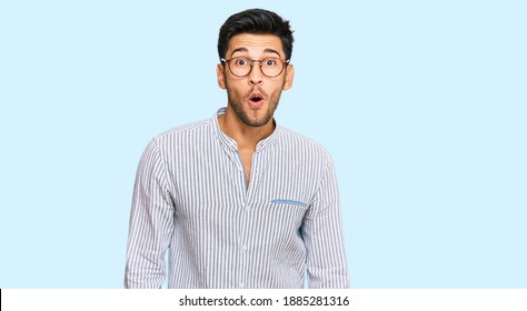Young handsome man wearing casual clothes and glasses afraid and shocked with surprise expression, fear and excited face. 