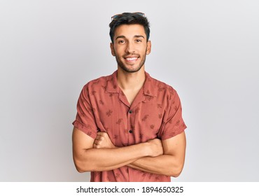 Young handsome man wearing casual summer clothes happy face smiling with crossed arms looking at the camera. positive person. 