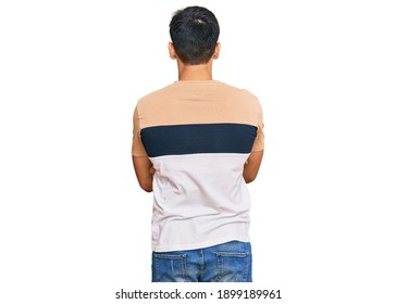 Young handsome man wearing casual clothes standing backwards looking away with crossed arms 