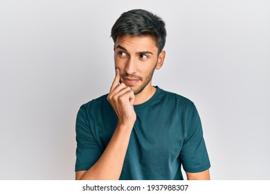 Young handsome man wearing casual clothes thinking concentrated about doubt with finger on chin and looking up wondering 