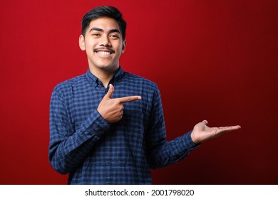 Young handsome man wearing casual shirt showing palm hand and doing ok gesture with thumbs up, smiling happy and cheerful over red background - Powered by Shutterstock