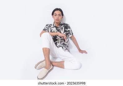 Young Handsome Man Wearing Casual Summer Shirt With White Pants Sitting In Studio,

