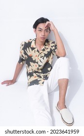 Young Handsome Man Wearing Casual Summer Shirt With White Pants Sitting In Studio,

