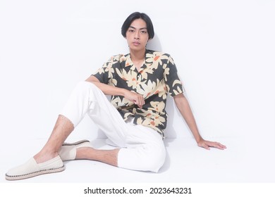 Young Handsome Man Wearing Casual Summer Shirt With White Pants Sitting In Studio,

