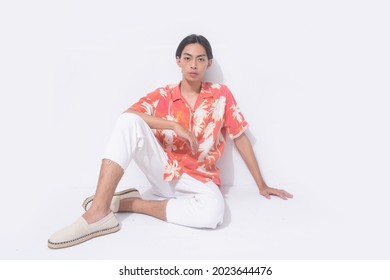 Young Handsome Man Wearing Casual Summer Shirt With White Pants Sitting In Studio,

