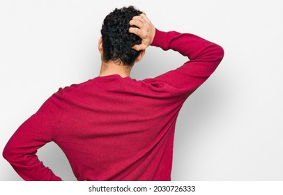 Young handsome man wearing casual clothes backwards thinking about doubt with hand on head 