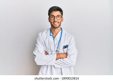 Young handsome man wearing doctor uniform and stethoscope happy face smiling with crossed arms looking at the camera. positive person. 