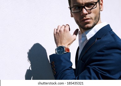 Young handsome man wearing fashion eyeglasses against neutral background with lots of copy space