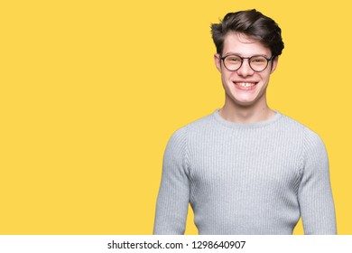 Young handsome man wearing glasses over isolated background with a happy and cool smile on face. Lucky person. - Shutterstock ID 1298640907