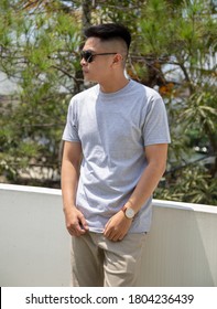 Young Handsome Man Wearing Heather Grey T Shirt Short Sleeve Was Posing At Outdoor