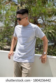 Young Handsome Man Wearing Heather Grey T Shirt Short Sleeve Was Posing At Outdoor