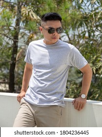 Young Handsome Man Wearing Heather Grey T Shirt Short Sleeve Was Posing At Outdoor