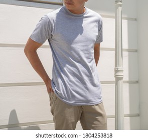 Young Handsome Man Wearing Heather Grey T Shirt Short Sleeve Was Posing At Outdoor