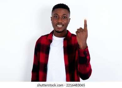 young handsome man wearing red plaid shirt over white  background smiling   looking friendly  showing number one first and hand forward  counting down