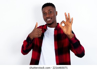 young handsome man wearing red plaid shirt over white  background smiling   looking happy  carefree   positive  gesturing victory peace and one hand