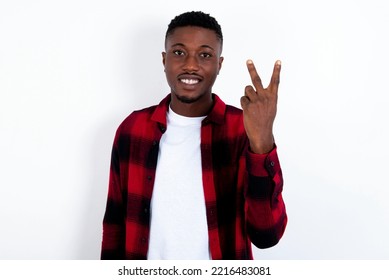 young handsome man wearing red plaid shirt over white  background smiling   looking friendly  showing number two second and hand forward  counting down