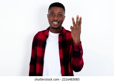 young handsome man wearing red plaid shirt over white  background smiling   looking friendly  showing number three third and hand forward  counting down