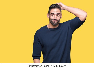 Young handsome man wearing sweater over isolated background confuse and wonder about question. Uncertain with doubt, thinking with hand on head. Pensive concept.