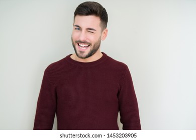 Junge, gut aussehende Mann mit einem Pullover auf isoliertem Hintergrund, die die Kamera mit sexy Ausdruck, fröhliches und glückliches Gesicht anschauen.