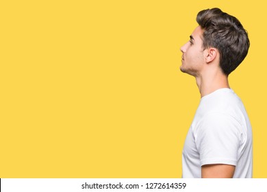 Young Handsome Man Wearing White T-shirt Over Isolated Background Looking To Side, Relax Profile Pose With Natural Face With Confident Smile.