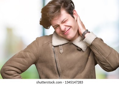 Young handsome man wearing winter coat over isolated background Suffering of neck ache injury, touching neck with hand, muscular pain