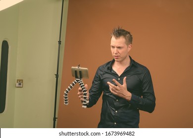 Young Handsome Man In Wet Clothes Against Brown Background