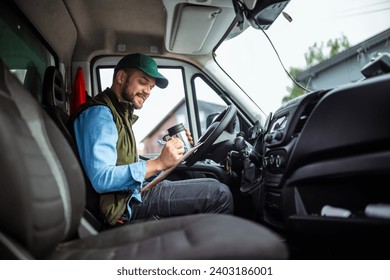 Young handsome man working in towing service and drinking coffee so he could get some energy - Powered by Shutterstock