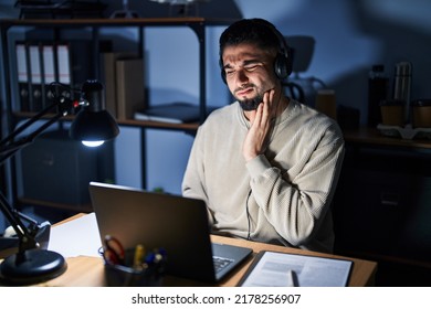 Young Handsome Man Working Using Computer Laptop At Night Touching Mouth With Hand With Painful Expression Because Of Toothache Or Dental Illness On Teeth. Dentist 