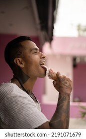 Young Handsome Mexican Tattooed Man Eating Ice Cream In A Waffle Cone.