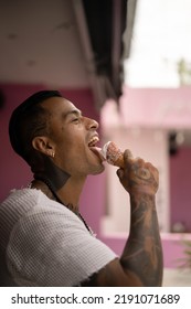 Young Handsome Mexican Tattooed Man Eating Ice Cream In A Waffle Cone.