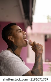 Young Handsome Mexican Tattooed Man Eating Ice Cream In A Waffle Cone.