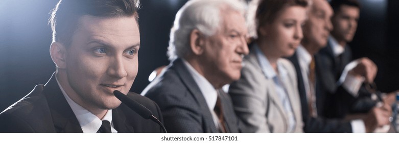 Young handsome politician fighting with opponents for electoral support during politicial debate - Shutterstock ID 517847101