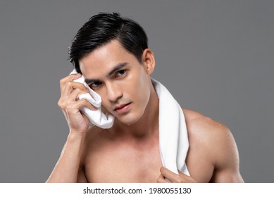 Young Handsome Shirtless Southeast Asian Man Wiping His Face With Towel In Isolated Studio Gray Background