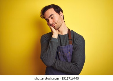 Young Handsome Shopkeeper Man Wearing Apron Standing Over Isolated Yellow Background Thinking Looking Tired And Bored With Depression Problems With Crossed Arms.