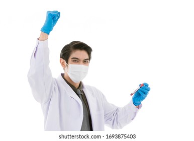 Young And Handsome Smart Asian Doctor Wearing Surgical Hygiene Protective Mask Isolated On White Background Holding Approved Test Tube Rise Hand Express Success And Cheerful Action. He Looks Happy.