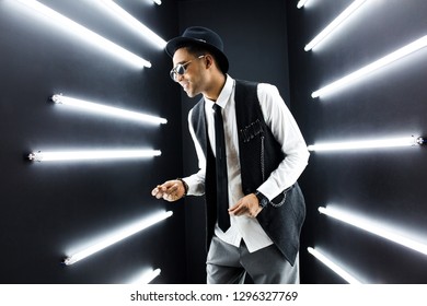 Young Handsome Smiling Hipster Black Man In Retro Vintage Style Suit Dancing Hip Hop In Disco Night Club, Having Fun