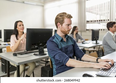 Young Handsome Student Using Computer In Classroom