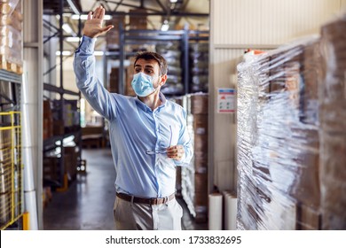Young handsome supervisor with protective sterile mask on waving and calling employee to come over. - Shutterstock ID 1733832695