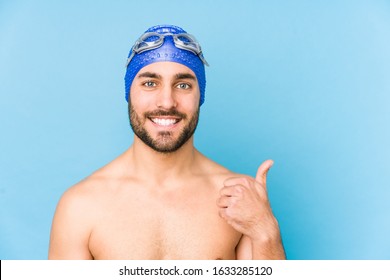 Young handsome swimmer man isolated smiling and raising thumb up - Powered by Shutterstock